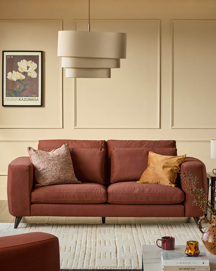 Burleigh 2-bulb pendant light in natural linen, displayed above a rust-colored sofa in a cream living room.