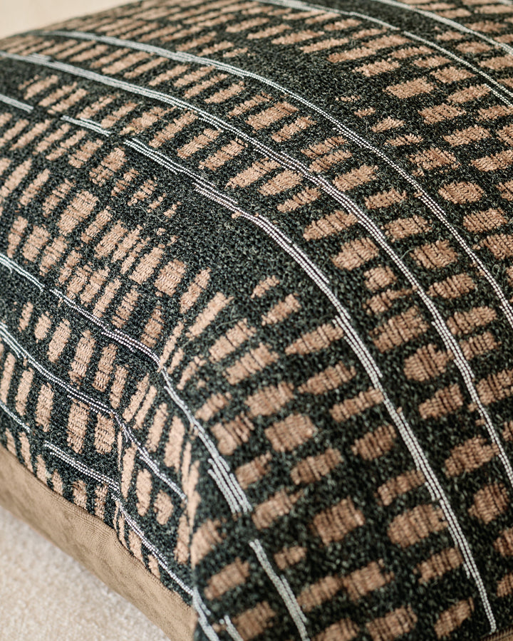 Close-up of black and beige checkered large cushion showing textured woven fabric and stitched seams.
