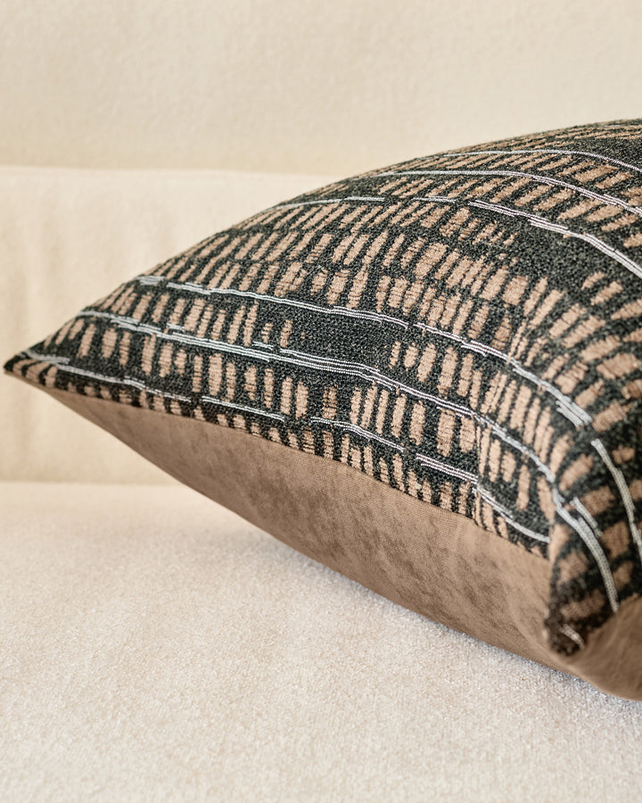 Rania Cushion Large in black, shown at an angle displaying its textured geometric pattern and neutral linen back panel.