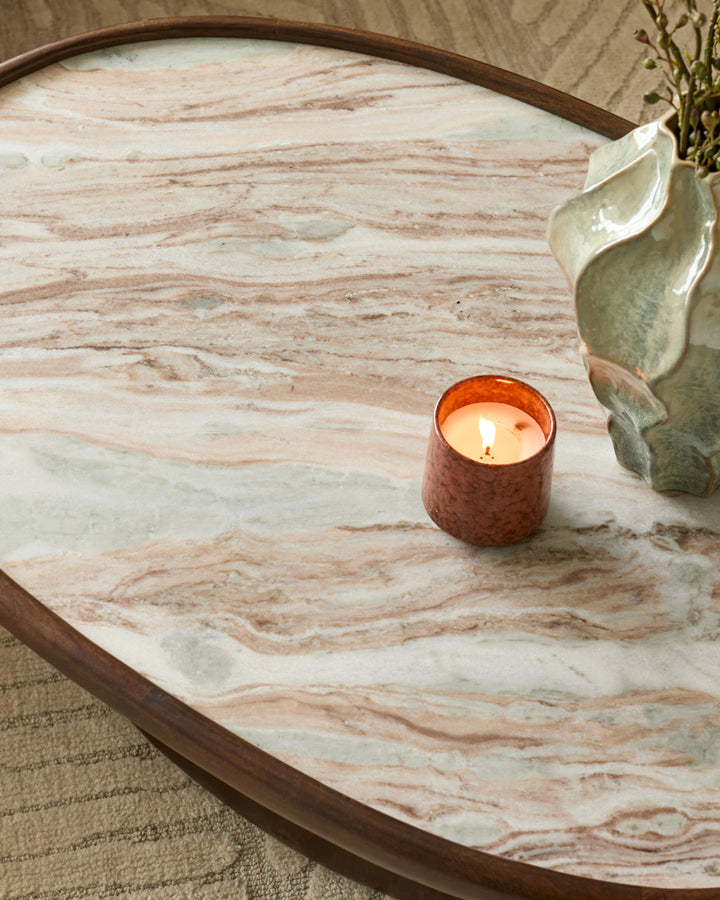 Rayna coffee table in dark wood with light marble top, styled with a lit candle and potted plant.