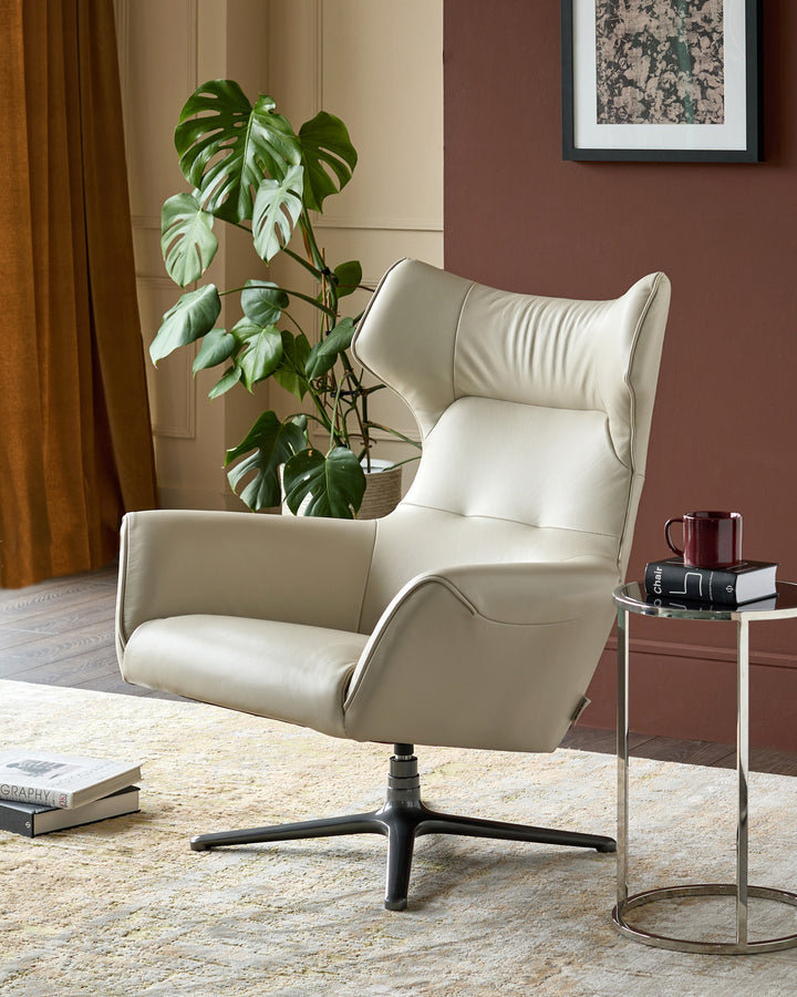Cream leather occasional chair with curved wings and high back, black swivel base, shown in room setting.