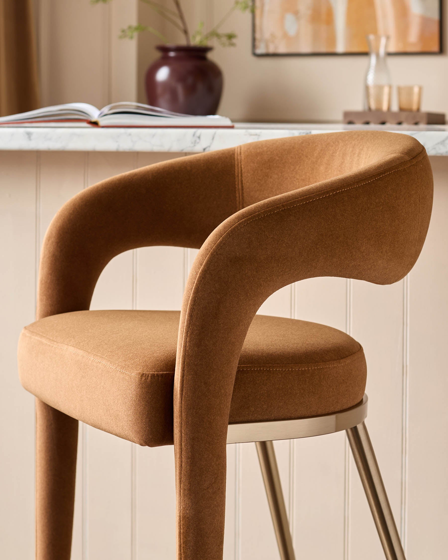 Close-up of a stylish, brown swivel bar stool with a curved back and metal legs. A modern design for your kitchen or bar area.