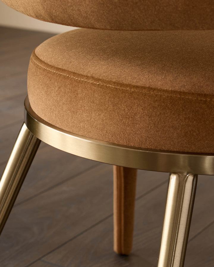 A close-up of a stylish stool, featuring a plush brown seat and sleek metal legs. Ideal for modern interiors.