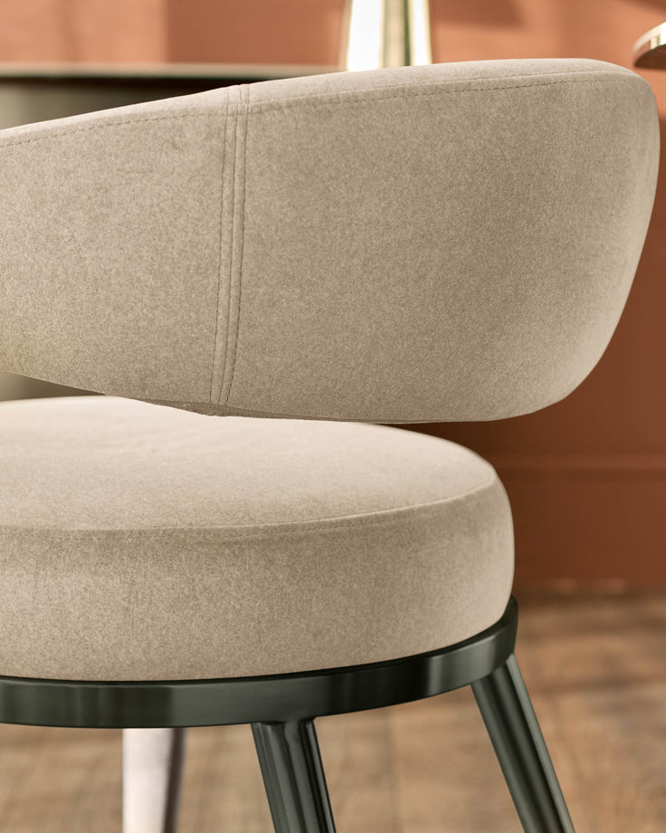 Rhett dining chair in champagne velvet, showing curved backrest and seat detail with black metal base.