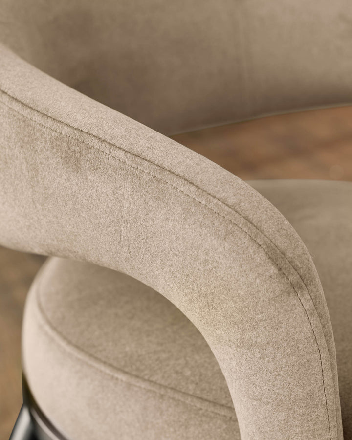 Rhett dining chair in champagne velvet, close-up of curved backrest and stitching detail.