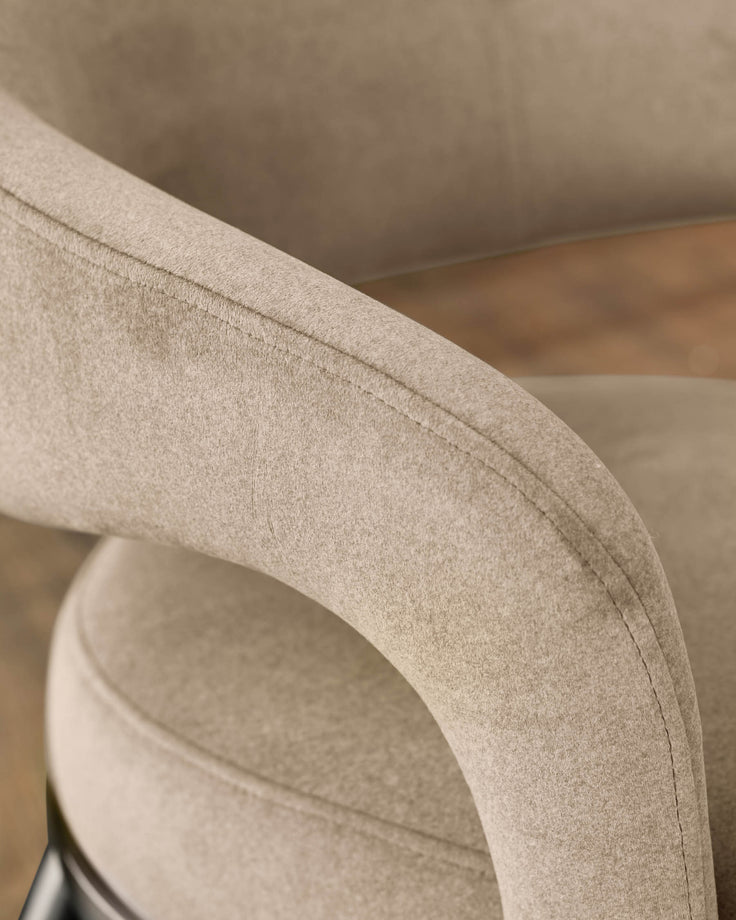 Rhett dining chair in champagne velvet, close-up of curved backrest and stitching detail.