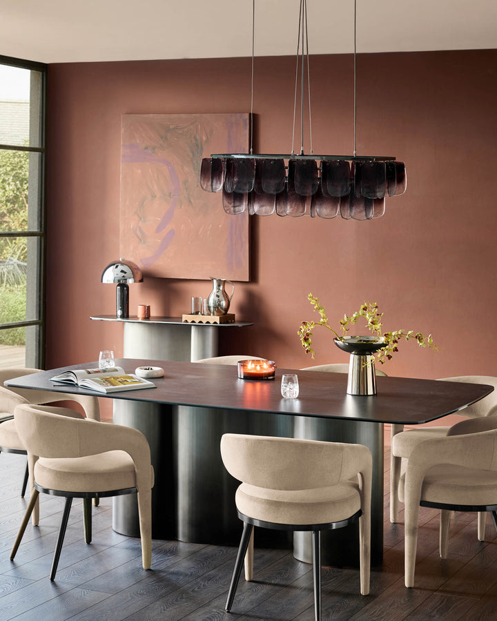 Champagne velvet dining chair with curved backrest and metal legs, shown in a modern dining room setting.