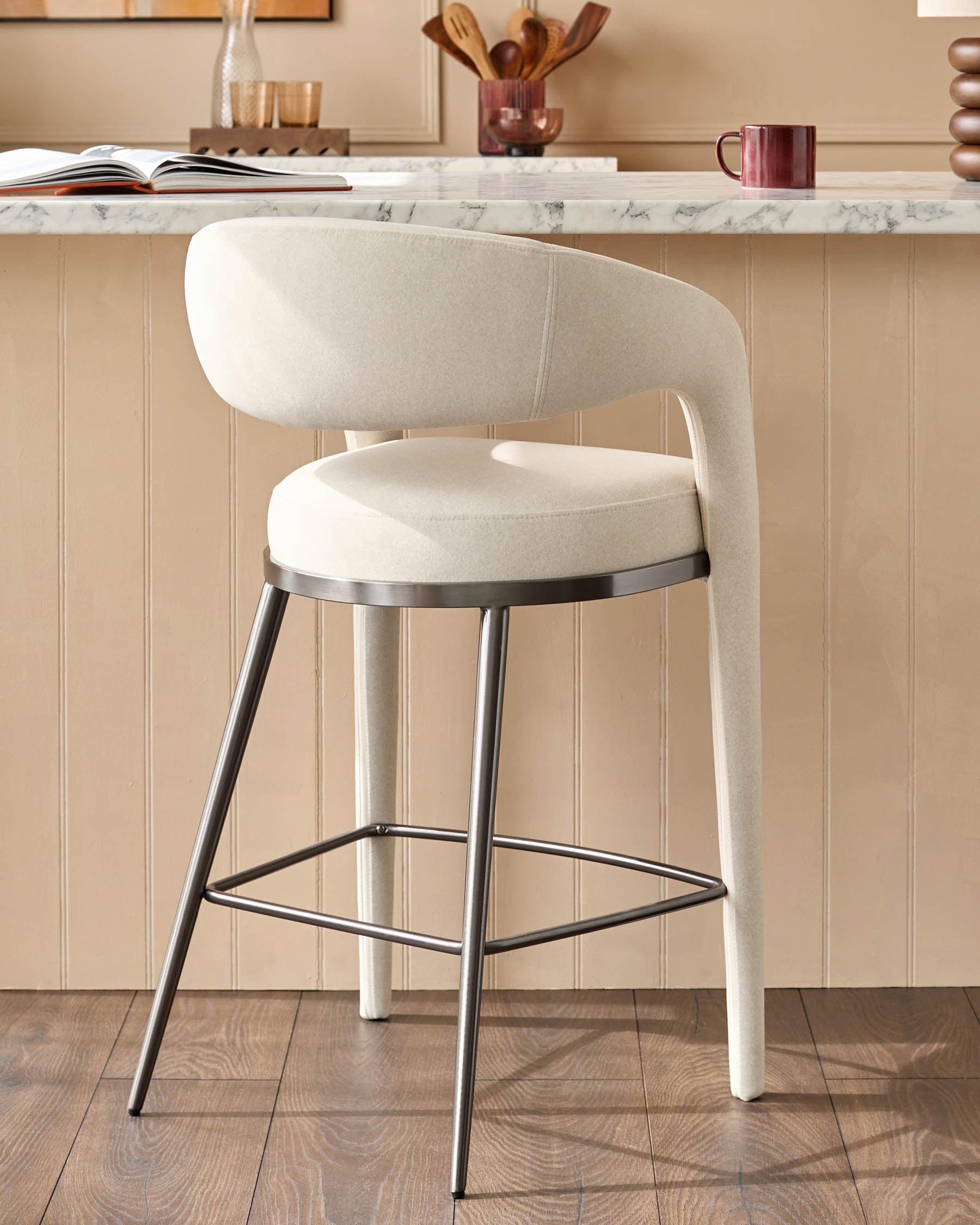 A stylish cream bar stool with a metal frame, perfect for modern kitchens and dining areas.