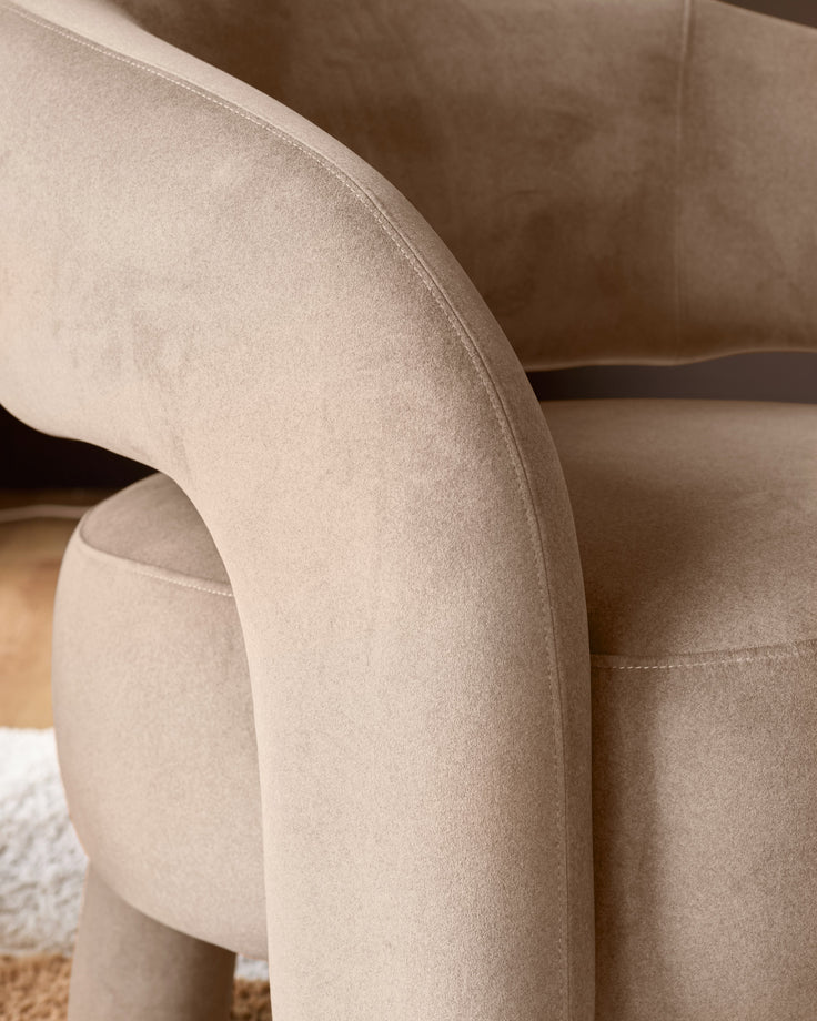 Rhett accent chair in natural fabric, close-up detail of curved armrest and seat showing soft upholstery texture.
