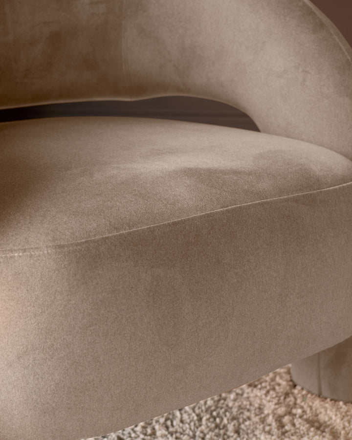 Rhett accent chair in natural fabric, close-up showing curved armrest and upholstered seat detail.