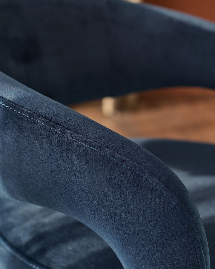 Close-up detail of dark navy velvet upholstery on Rhett dining chair, showing seam stitching and soft texture.