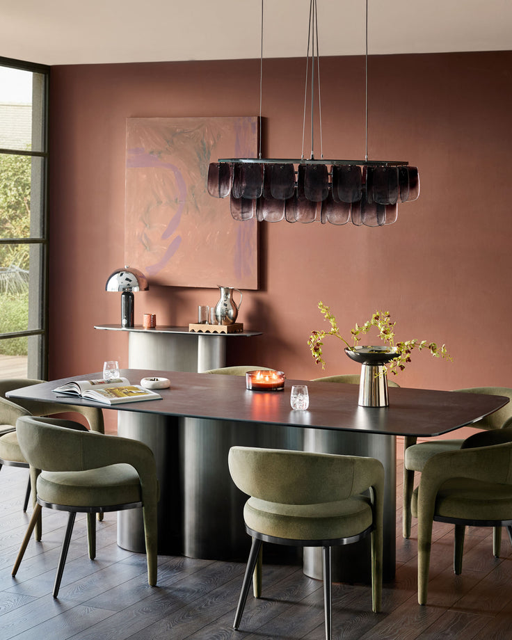 Olive green fabric dining chair with curved backrest and metal legs, shown in modern dining room setting.