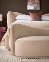 Champagne velvet accent sofa with curved arms and rounded silhouette, displayed in bedroom setting.
