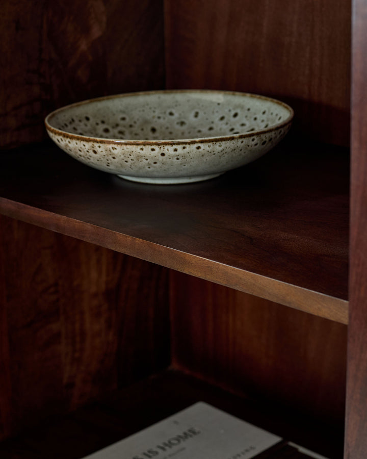 Dark mango wood sideboard with open shelf displaying a speckled ceramic bowl.