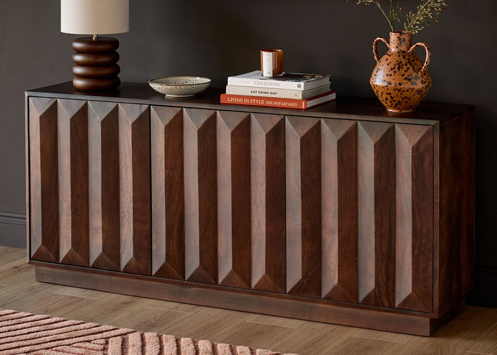 Ria Large Sideboard in dark mango wood with geometric fluted front panel design, styled with lamp and decorative accessories.