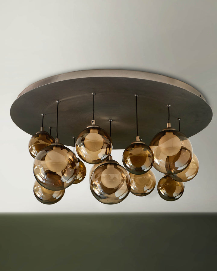 A stylish, modern ceiling light fixture with bronze-tinted glass globes hanging from a circular metal base.