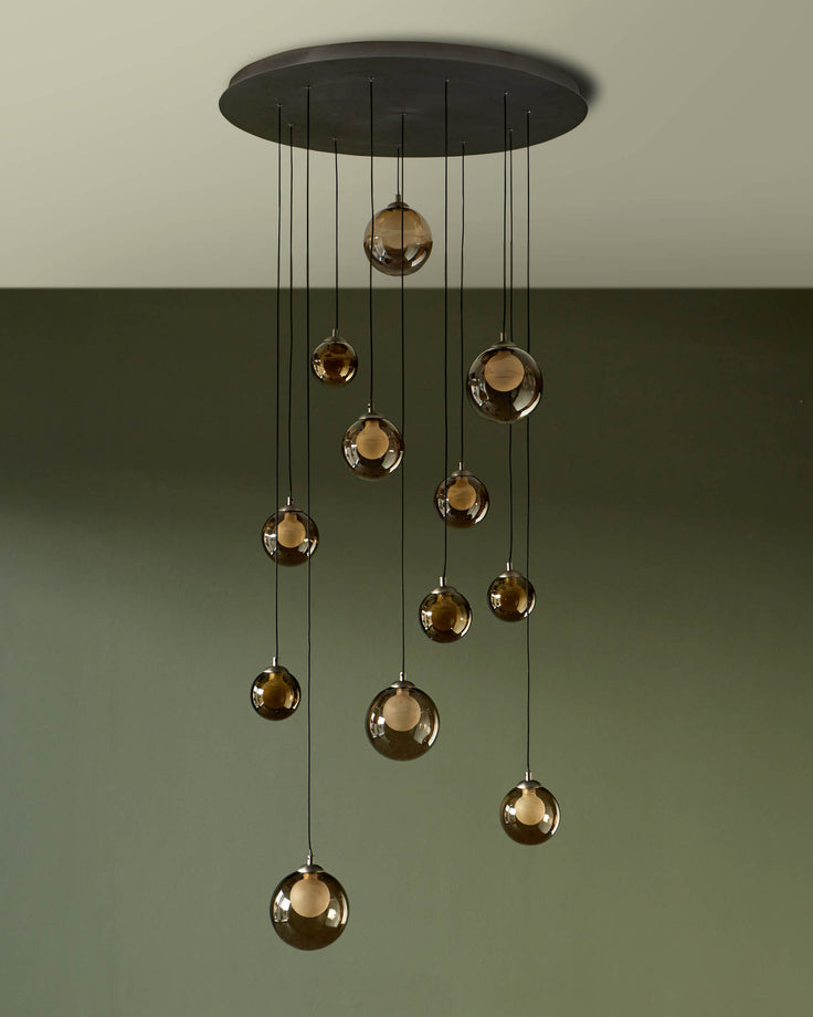 A stylish pendant light with cascading smoked glass globes, suspended from a circular ceiling plate. Adds modern elegance to any space.