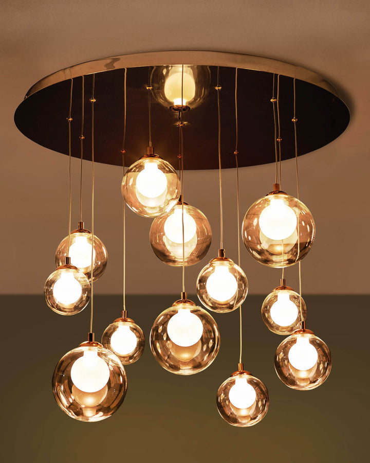 A stylish ceiling light fixture with multiple glass globe lamps, suspended from a circular plate in varying lengths.