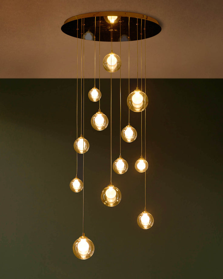 A modern, multi-bulb pendant light with spherical glass shades and golden accents, adding a warm ambience to any room.