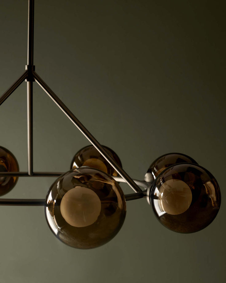Contemporary ceiling light fixture featuring smoked glass globes and a sleek metal frame. Modern lighting for stylish interiors.