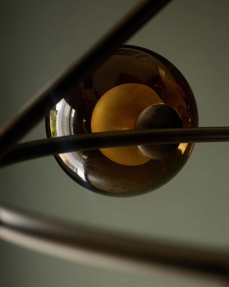 A modern light fixture with brown glass orbs and metal framework. Creates a stylish and contemporary aesthetic.