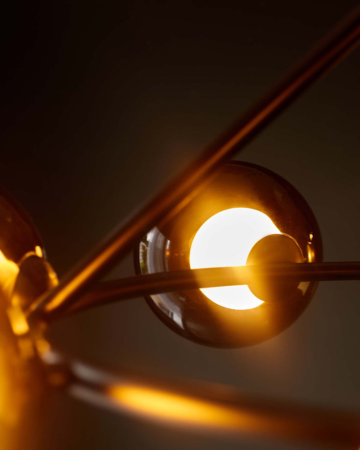 Close-up of a stylish, modern light fixture with glowing spherical shades and sleek metal arms.