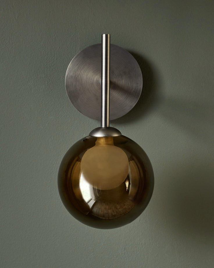 Stylish wall light with a brushed metal base and an amber-tinted glass globe. Adds a touch of elegance to any room.