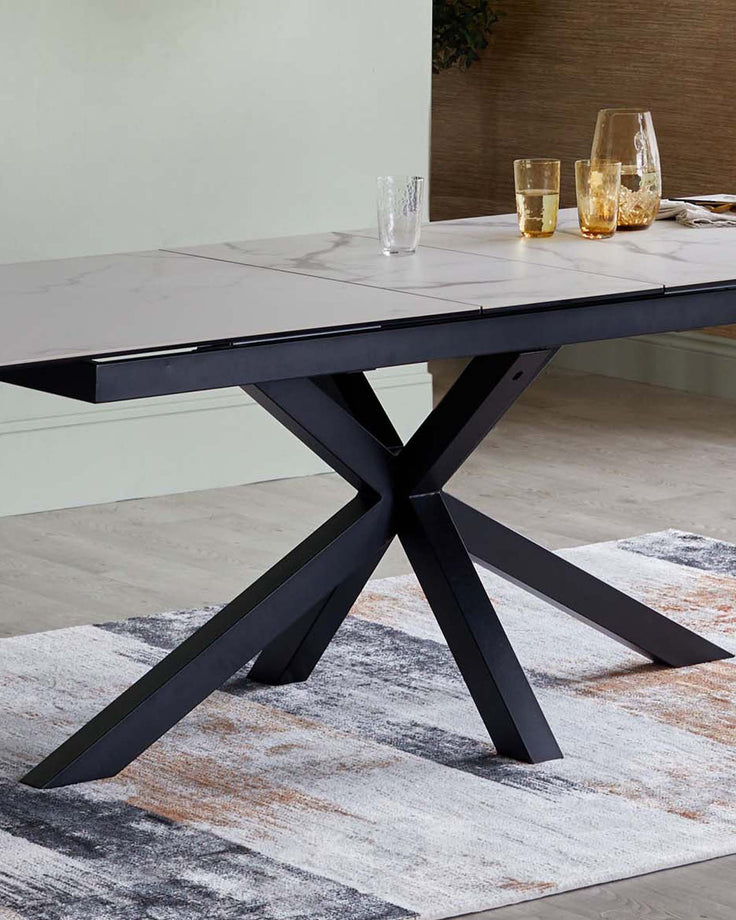 Riley ceramic extending table in white with black metal X-frame base, shown extended in a modern dining setting.