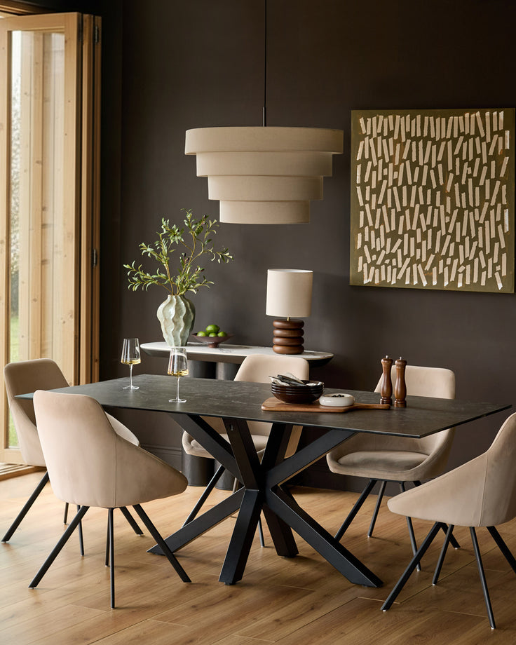 Riley 8-seater dining table in dark grey ceramic with black X-frame base, styled in modern dining room.