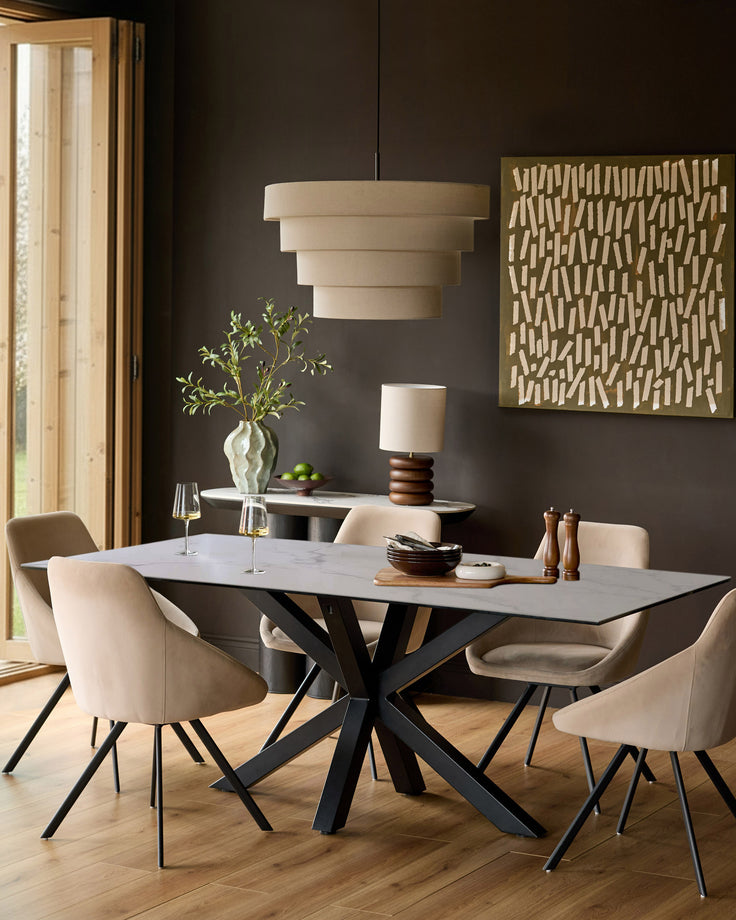 Riley 8-seater dining table in ceramic white with black crossed-leg base, styled in a modern dining room setting.