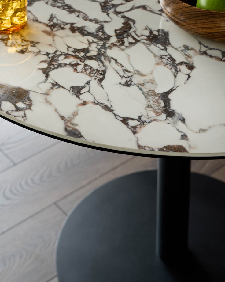 Marble table with black base, offering a luxurious touch. Ideal for modern interiors, blending elegance with minimalist design.