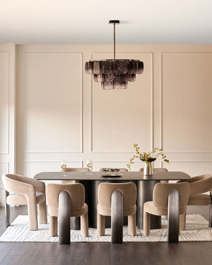 Rosalie dining chair in champagne fabric, curved barrel-back design, shown at modern dining table.