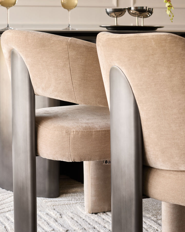 Rosalie dining chair in champagne fabric with white wooden frame, shown at an angle in a styled dining setting.