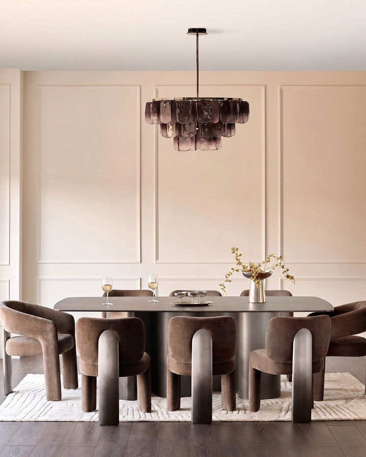 Mocha fabric dining armchair with curved backrest and cylindrical legs, shown in modern dining setting.