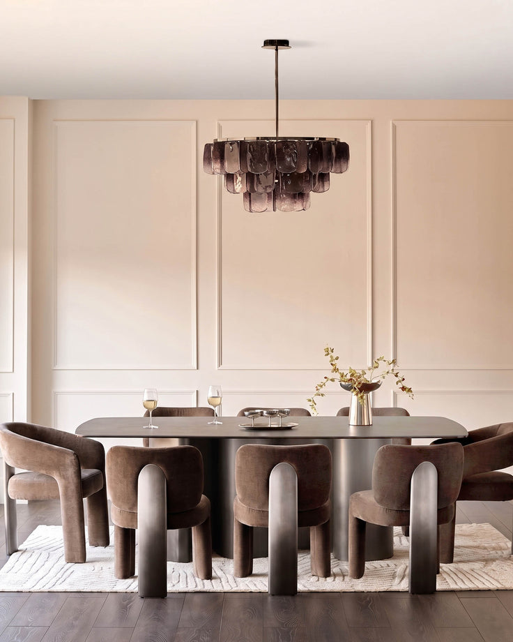 Mocha fabric dining armchair with curved backrest and cylindrical legs, shown in modern dining setting.