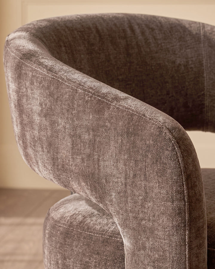 Rosalie dining armchair in mocha fabric, close-up of curved backrest and armrest showing textured weave detail.