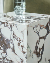 Marble cube side table with a glass of water, adding a touch of sophistication to any modern living space.