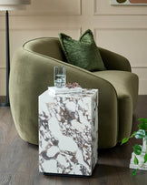 Stylish olive green velvet chair with a marble side table. Includes home decor accessories.