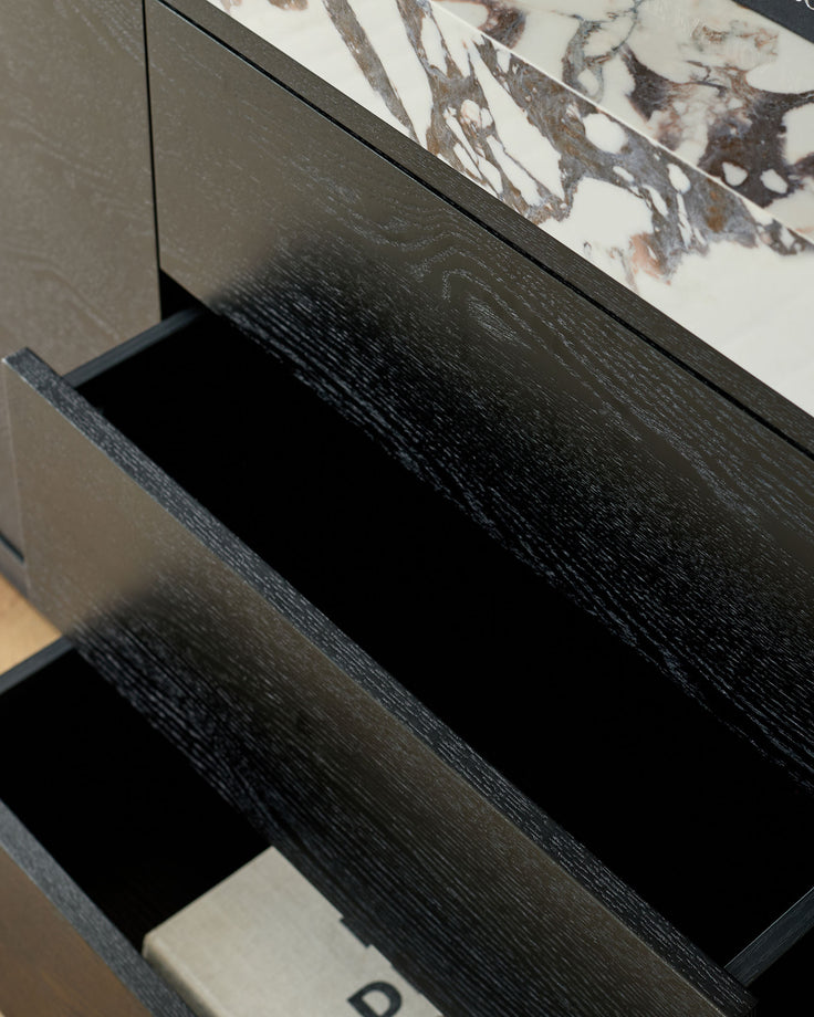 Russo sideboard with open drawer showing black wood grain finish and white Calacatta marble top detail.