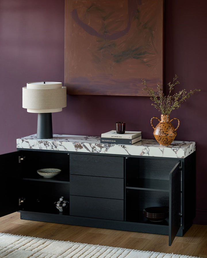 Russo sideboard in black with Calacatta white marble top, featuring open shelving and drawers in a modern room setting.