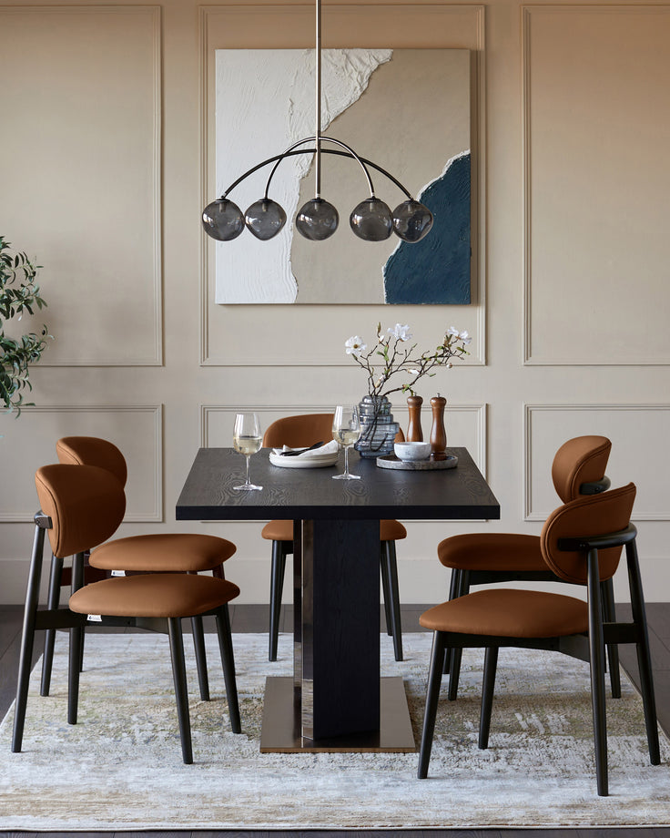 Tan leather Ryann dining chair with curved backrest and black wooden legs, shown in a styled dining room setting.