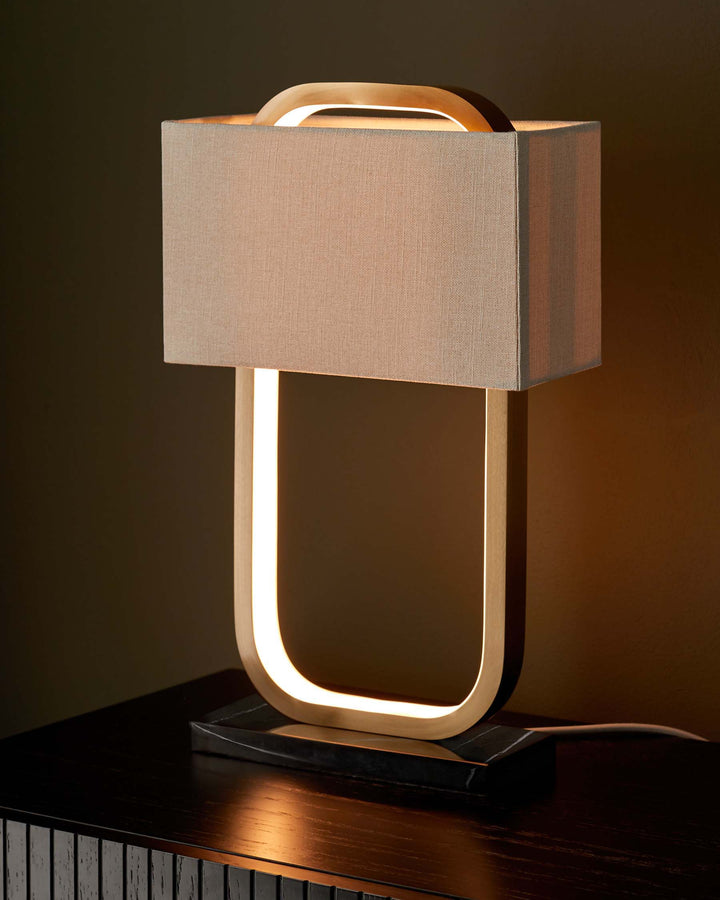 Stylish modern lamp with a rectangular shade, sleek frame, and marble base sitting on a dark wood cabinet.