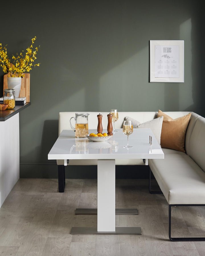 Modern dining area with white extending table, bench seating, drinks and yellow flowers. Ideal for a stylish dining space.