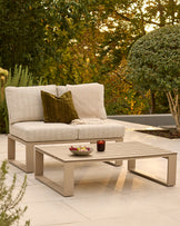 Savannah garden daybed set in natural finish with beige cushions and olive pillow, paired with matching coffee table in outdoor setting.