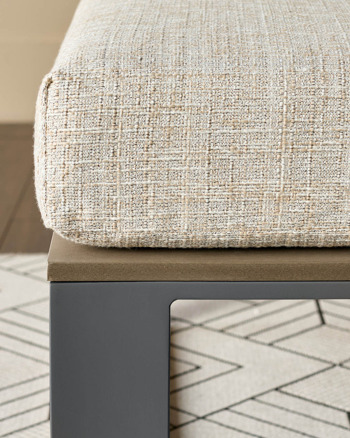 Cream textured fabric seat cushion on black metal frame with taupe cushion base, angled view.