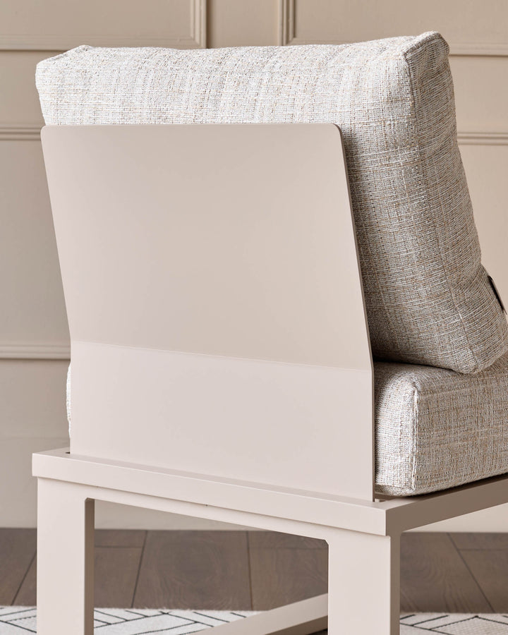 Savannah Garden corner bench with natural cushion and white wooden base, shown from side angle against paneled wall.