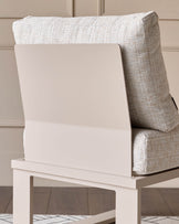 Cream upholstered armchair with natural wood frame, shown from a side angle against a neutral background.