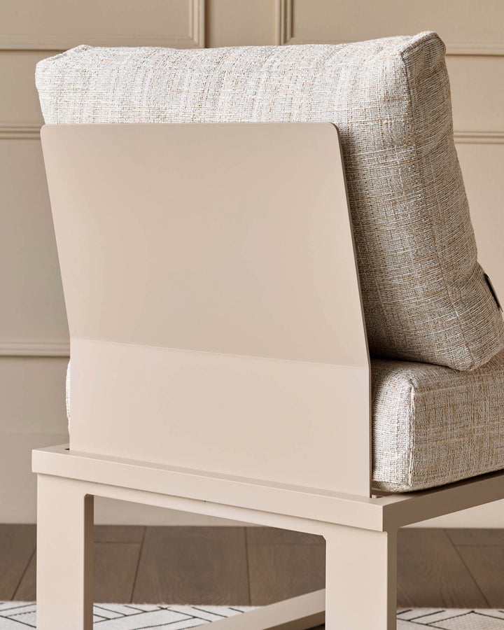 Cream upholstered chair with textured beige cushioning, paired with white wooden base frame, angled side view.