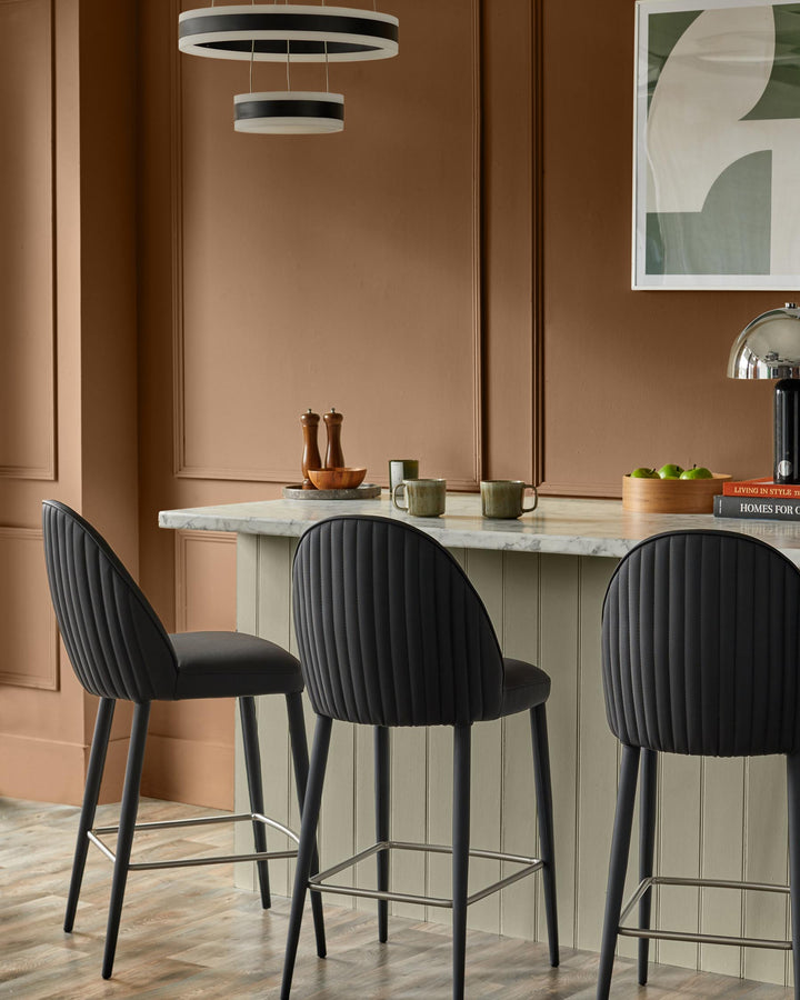 Stylish bar stools at a kitchen island, with modern lighting and decor. Perfect for a contemporary home.