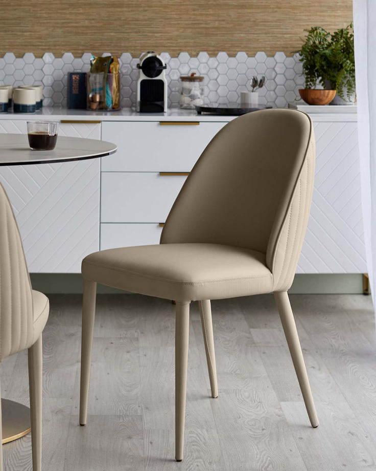 A stylish dining room featuring modern upholstered chairs with sleek, angled legs, paired with a round table.
